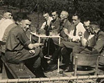 Karl Höcker (on left, looking at the camera) relaxes with SS physicians, including Dr. Fritz Klein (far left), Dr. Horst Schumann (partially obscured next to Klein, identified from other photographs), and Dr. Eduard Wirths (third from right, wearing tie).