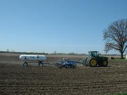 A tractor driving on some farm land.