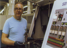 Photo of employee working on a machine.