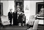President Dwight Eisenhower and Mamie Eisenhower receive a donation of antique furniture for the Diplomatic Reception Room of the White House on June 29, 1960. The Federal style furniture includes a pale gold silk sofa and matching chairs. Joining the Eiswenhowers are Michael Greer of the National Society of Interior Designers, Inc. and designer Dora Brahms.
