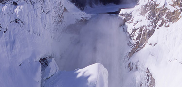 Lower Falls of the Grand Canyon of the Yellowstone blanketed and frozen in snow.