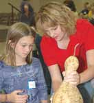 NRCS District Conservationist Allison Orr shows a youngster how to build a gourd bird house.