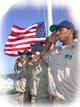 Maritime students saluting, with U.S. flag in background