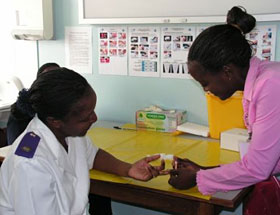 Taimi Monica Nyangele (right), a community counselor in a Namibian Ministry of Health facility, receives training in rapid testing from Helena Hidenywa, a nurse.