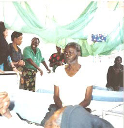 Mary–Gorretti (smiling in back), who is HIV-positive, works at Minga Hospital’s hospice section and now coordinates the hospital’s home-based care activities.