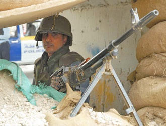 شرطي عراقي يحمل مدفع رشاش في نقطة تفتيش في منطقة الصالحية في بغداد في 10 أيلول/سبتمبر. علماً بأن الصالحية هي أوّل منطقة في بغداد يتم فيها نقل جميع نقاط التفتيش من مسؤولية الجيش العراقي إلى مسؤولية الشرطة العراقية