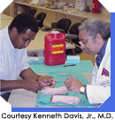 Dr. Kenneth Davis, Jr. with medical student David Burgess practicing suturing, Courtesy Kenneth Davis, Jr., M.D.