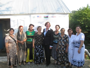 US Ambassador Anne Derse stands with local women in front of the new water pump house. Women in Tazakand were active participants in the Community Development Council’s efforts to rehabilitate its irrigation system.