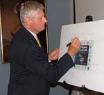 NRCS Regional Assistant Chief East Dick Coombe signs a memento 2008 Gulf Hypoxia Action Plan cover