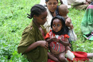 A woman feeds her malnourished daughter at a community feeding program in Ethiopia.