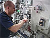 Astronaut Clayton Anderson prepares a plant growth chamber on the space station