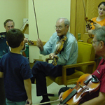 Musicians young and old practice fiddling at Prairie Acadian Cultural Center.