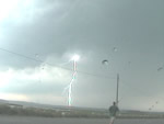 man standing near power lines with lightning striking