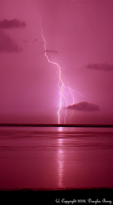 lightning in pink sky over water