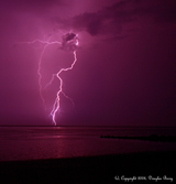 lightning in pink sky over water
