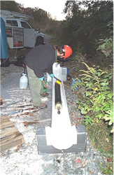 USGS technician decontaminating the BAT3 in a water bath at the University of Connecticut Landfill Study Area, Storrs, CT