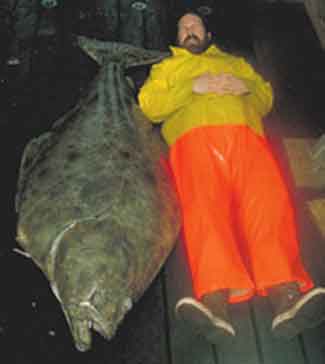 Adult halibut and equally tall (long) fishery biologist.