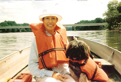 woman and dog in a boat wearing lifevests