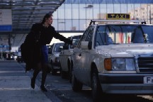 Image of one woman getting on a taxi at the airport
