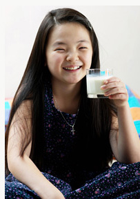 a girl holding a glass of milk