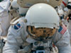 Harrison H. Schmitt, lunar module pilot, simulates scooping up lunar sample material.