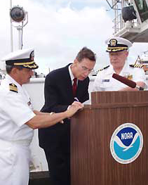 NOAA administrator signs documents authorizing the transfer of of a former Navy ship to NOAA to be used as an ocean exploration vessel.