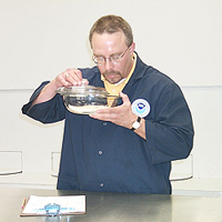 A NOAA seafood tester examines seafood as part of a sensory test.