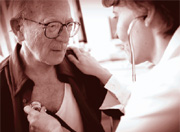 Image of nurse listening to male patient's heartbeat