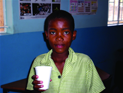 Photo of Namibian boy enjoying a cup of nutritious yogurt.