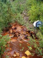 During a pH modification experiment conducted in Mineral Creek, Colo., the pH of the stream changed from about 3.0 to about 8.0 (acidic to mildly basic). The change in pH caused the older precipitates in the stream to be covered by a new precipitate (ferrous iron hydroxide). A solution of a base (sodium hydroxide) was injected into the stream to change the pH