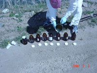 Filling sample bottles with liquid collected from a municipal holding pond in Colorado as part of the Source Characterization Study for Emerging Contaminants Project. The multiple sample bottles are required for the analysis of different classes of emerging contaminant compounds