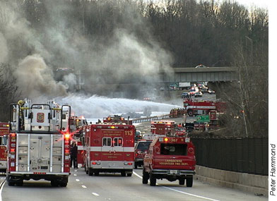 Truck blasts foam on the fire and surrounding area, local fire unit remain ready to assist