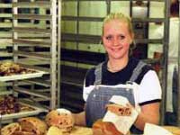 Woman preparing muffins in bakery