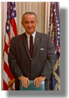small picture of LBJ standing behind desk