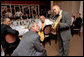 Trumpeter Irvin Mayfield shows President George W. Bush the Elysian Trumpet during a dinner with cultural and community leaders Tuesday, Aug. 28, 2007, at Dooky Chase Restaurant in New Orleans, La. Dedicated to those who perished in Hurricane Katrina, the trumpet is named for the neighborhood where Mr. Mayfield's father drowned during the storm. Representing New Orlean's spirit, the instrument is decorated with symbols of the city. White House photo by Chris Greenberg