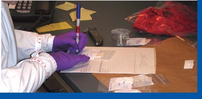 Photograph of a laboratory evidence analyst inventories evidence