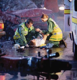 Photo of rescue workers attending an injured person after a crash.