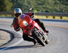 Photograph of a motorcycle going through a curve on a winding road.