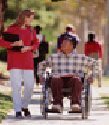 girl walking with boy in wheelchair