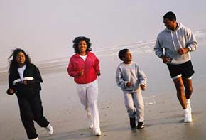 Family running on the beach together