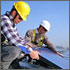 Thumbnail photo of two men installing a photovoltaic module on the roof of a building.