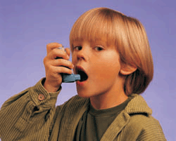 A young boy using an inhaler. 