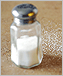 a photo of a salt shaker and spilled salt