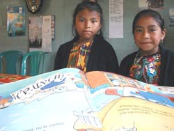 Kaqchikel Mayan girls look at their new school books in Sumpango, Sacatepequez, Guatemala.