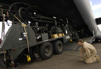 Airman 1st Class Joshua Weston spots while Navy Seabees unload a water-well drilling rig from a C-17 Globemaster III that was transported, along with 20 Navy Seabees, to Nairobi, Kenya from Camp Lemonier, Djibouti in support of a humanitarian well drilling mission enabling critical water supplies to regions in severe drought conditions. Airman Weston is assigned to the 816th Expeditionary Airlift Squadron as a C-17 Loadmaster and is deployed from Charleston Air Force Base, S.C. (U.S. Air Force Photo By: Staff Sgt. Christina M. Styer) 