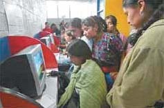 Photo of a Guatemalan woman on a computer as others watch.