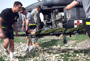 Soldiers and U.S. soldiers load an Iraqi teenager injured by an improvised explosive device onto a medical evacuation helicopter near Kirkuk, Iraq, March 27, 2008. The soldiers are assigned to the 10th Mountain Division's Company C, 2nd Battalion, 1st Aviation Brigade.