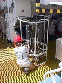 A NMFS scientist collects a water sample from the CTD after it is recovered.