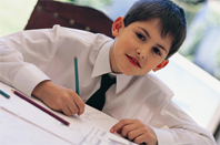 A formally dressed up child writing with a pencil