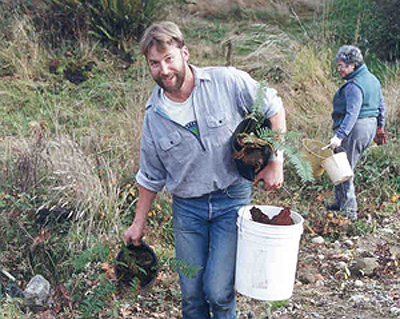 Plant salvager carrying ferns off site